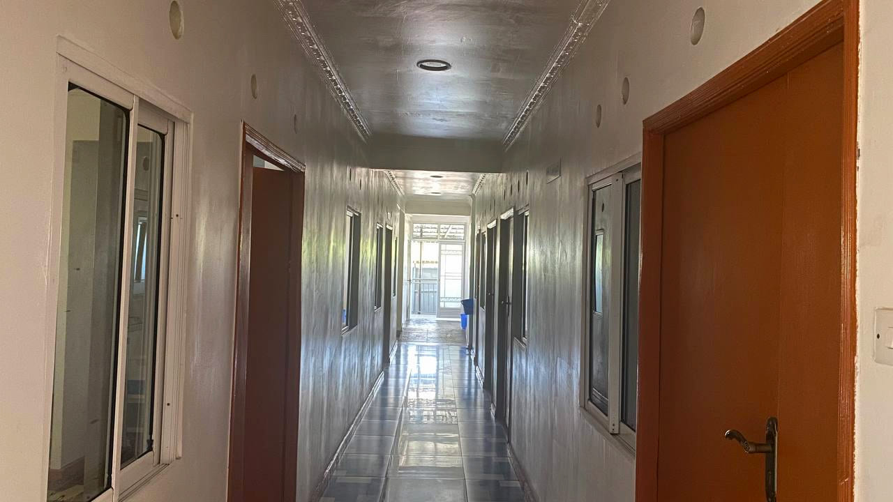 The pharmacy counter and triage room inside Namo Hospital, both signed and open to the main corridor.